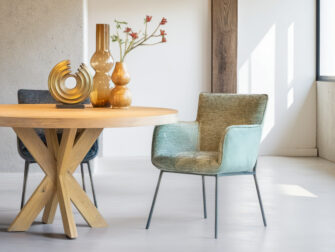 Eetkamerstoel in groenkleurige stof met minimalistisch zwart onderstel