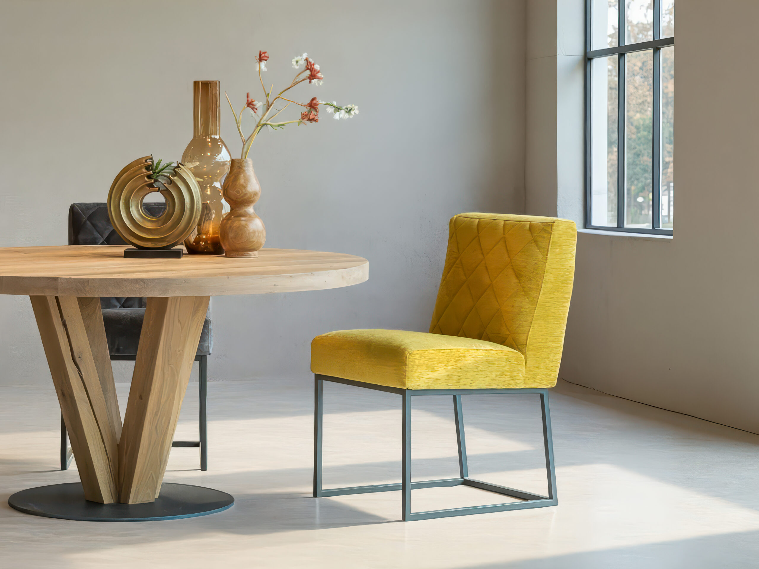 goudkleurige stoel bij een ronde eetafel