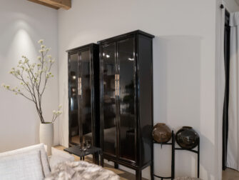 hoge vitrinekasten van oud Chinees hout met een glanzende afwerking en elegante deuren