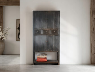 Houten kast in old black afwerking met klassieke handgrepen en subtiele slijtage-details