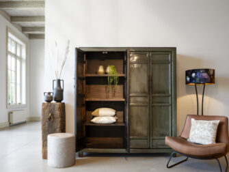 Grote vintage opbergkast in groen gelakte afwerking met geopende deur, voorzien van houten legplanken