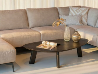 salontafel met organische kiezelvorm en zwarte houten poten