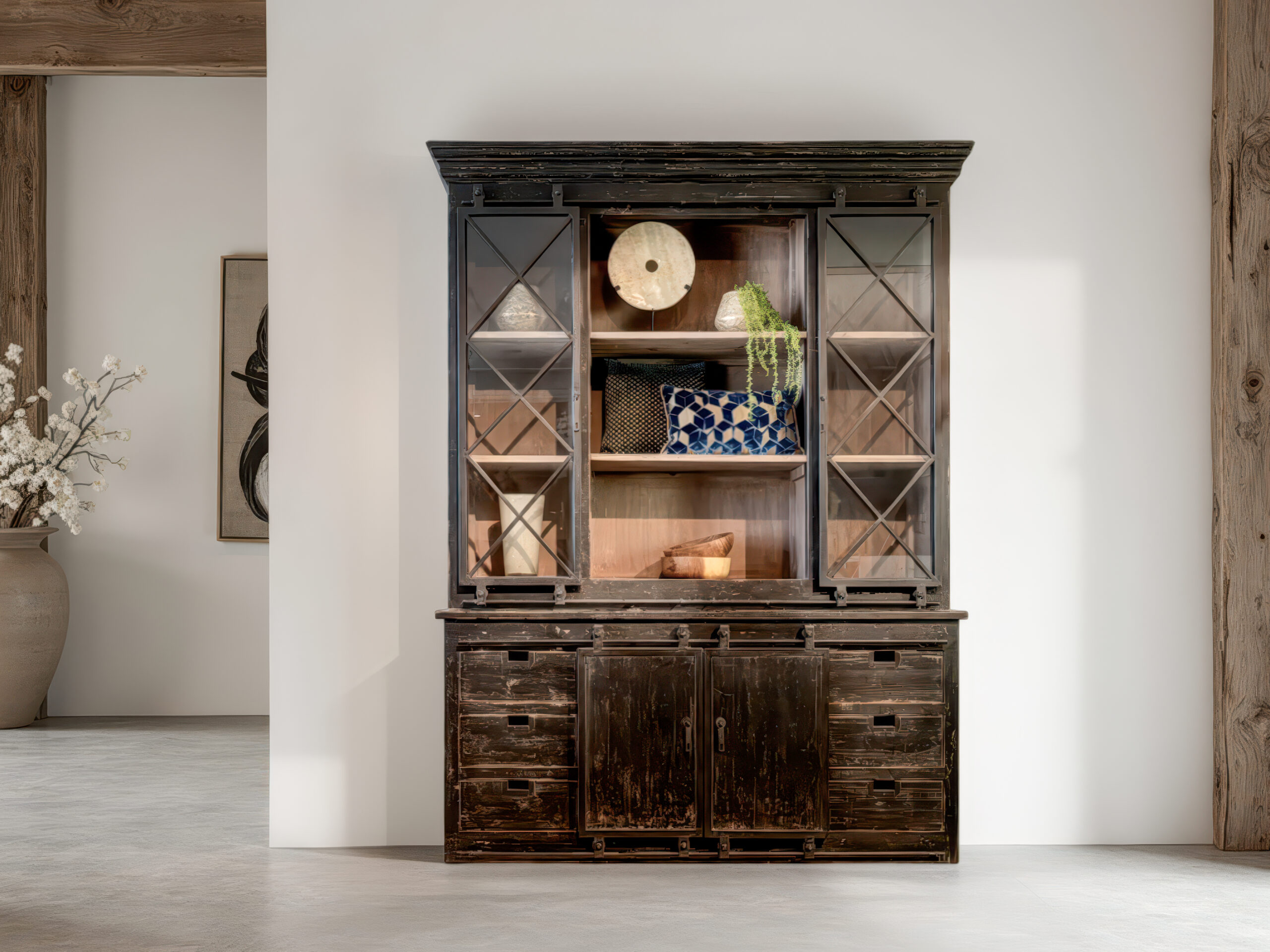 Zwarte houten vitrinekast met rustieke uitstraling en decoratieve elementen in het open middenvak
