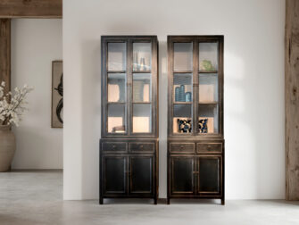 landelijke vitrinekast van zwart hout met glazen deuren en sierlijke details