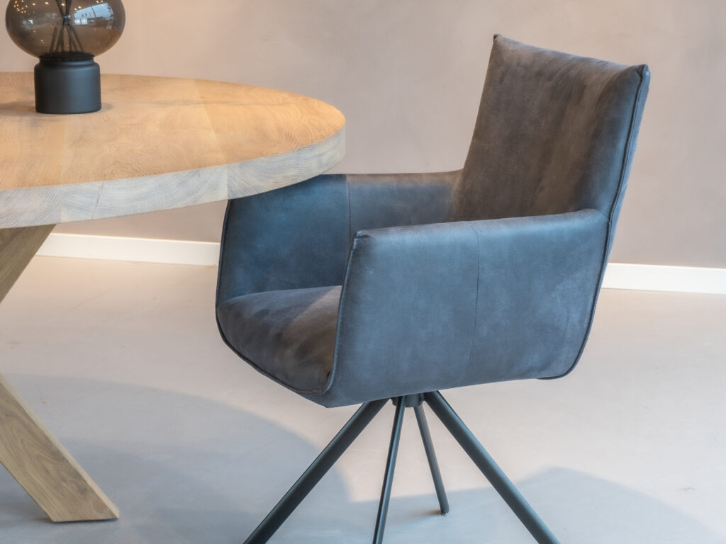 Donkerblauwe eetkamerstoel met armleuning en stijlvolle stiksels.