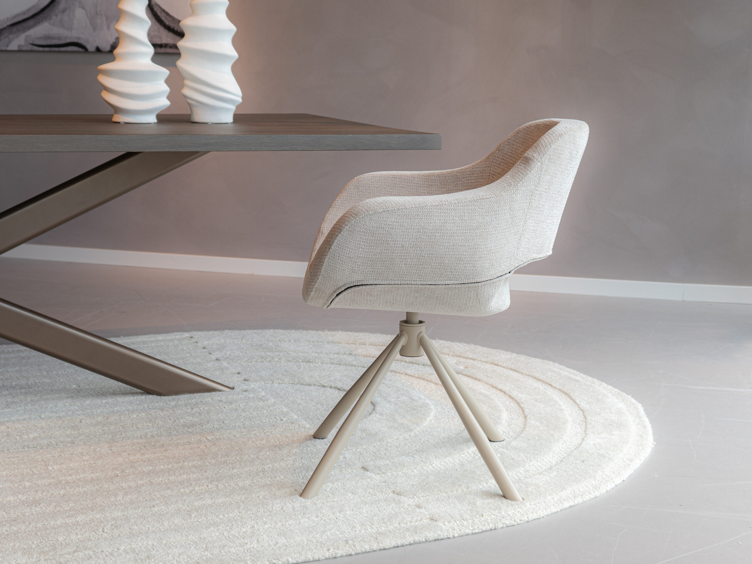 Eetkamerstoel in zachte beige stof met een lichtkleurig draaibaar onderstel