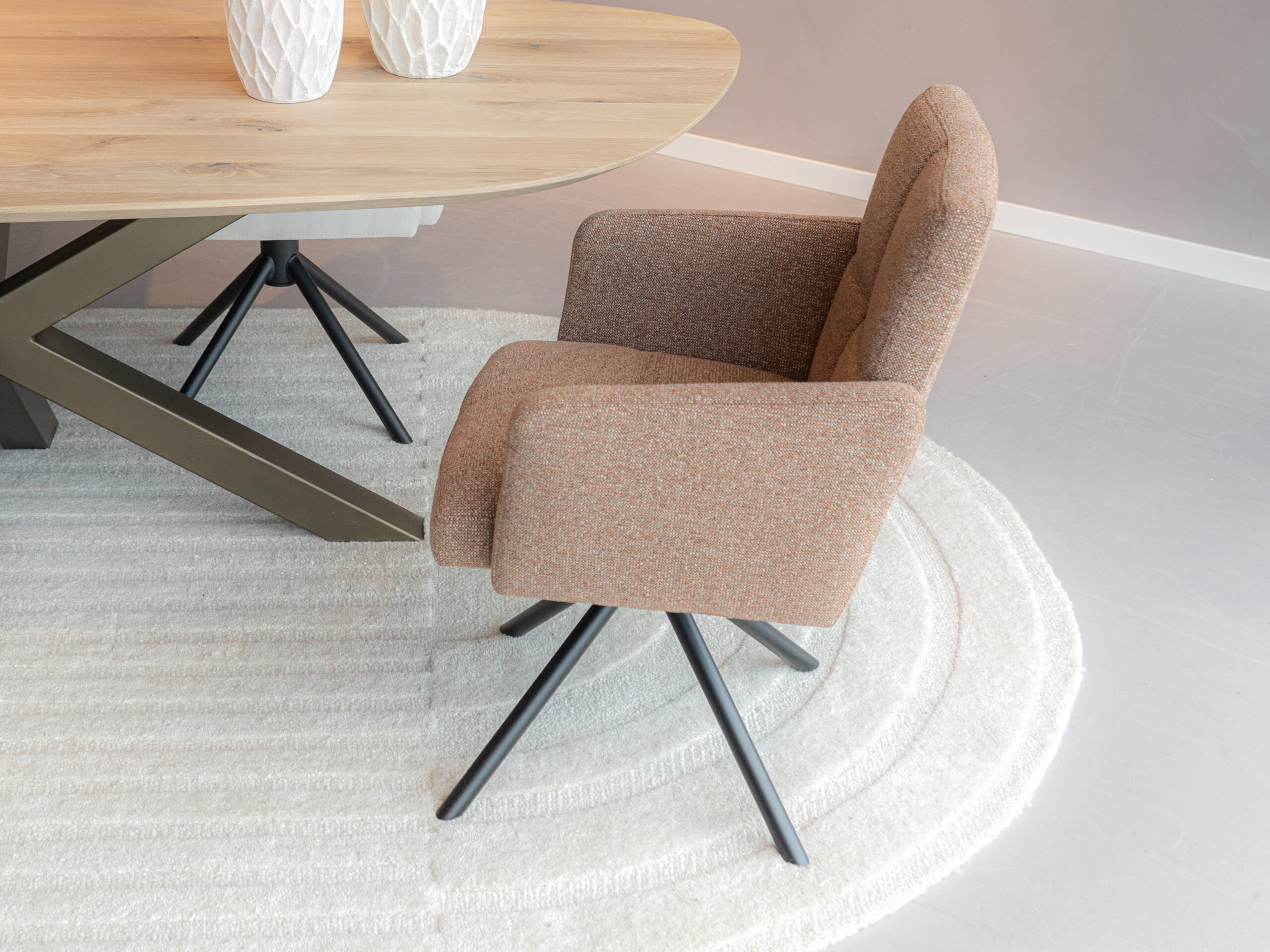 Draaibare eetkamerstoel met cognac kleurige stof en zwart onderstel