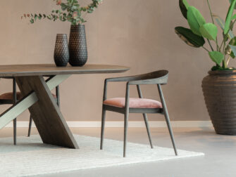 sfeervolle eetkamerstoel met een klassieke houten look en een moderne roze zitting