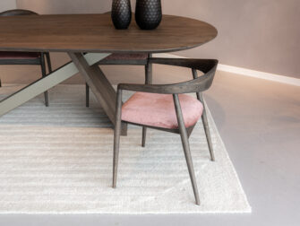 stoel met houten poten en een stijlvolle roze stoffen zitting, perfect voor een moderne eetkamer