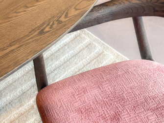 lichtgewicht houten eetkamerstoel met een gebogen rugsteun en een fluwelen roze zitvlak