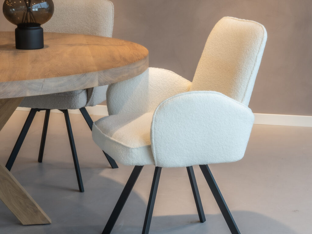 Moderne eetkamerstoel in strak witte stof voor een hedendaagse eetkamer.