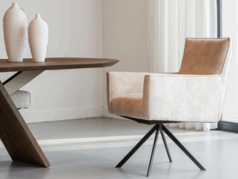 Eetkamerstoel met stoffen bekleding en zwart metalen draaipoot