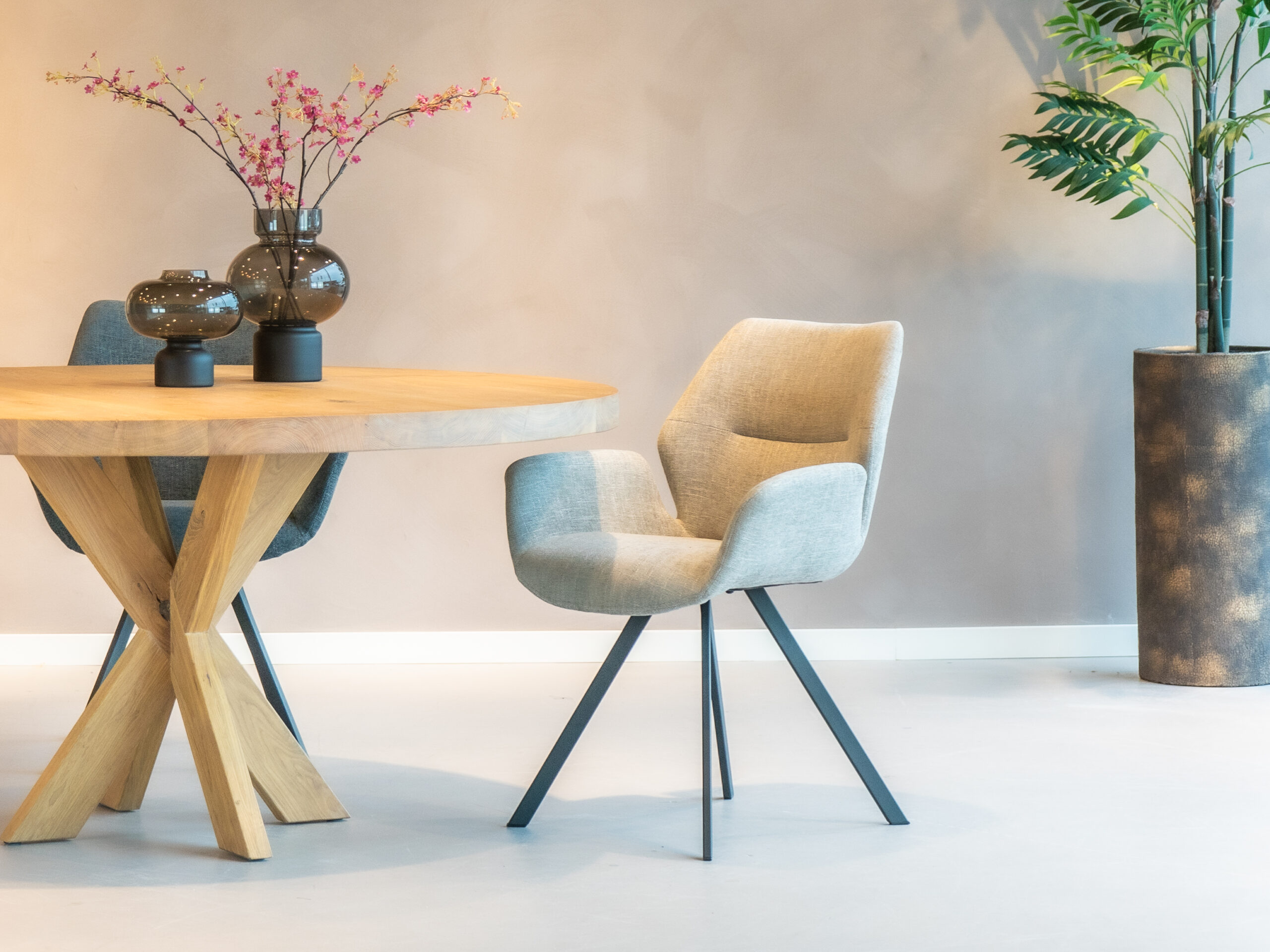 Taupe eetkamerstoel met een elegant ontwerp en comfortabele zitting.