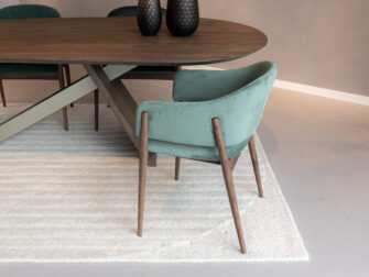 Eetkamerstoel met donkere houten poten in groene stof