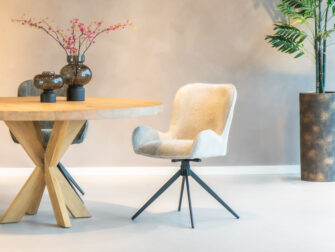 Zandkleurige eetkamerstoel met een elegant ontwerp en stijlvolle stiksels.