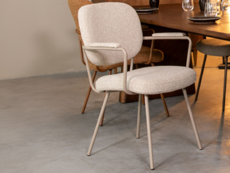 Stoel met zachte tinten en armleuningen, met licht metalen onderstel en comfortabele zitting