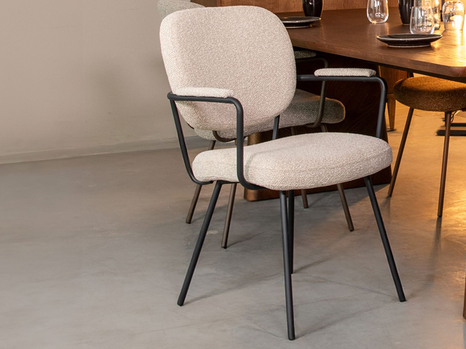 Naturel Boucle eetkamerstoel met zwarte armleuningen en metalen frame