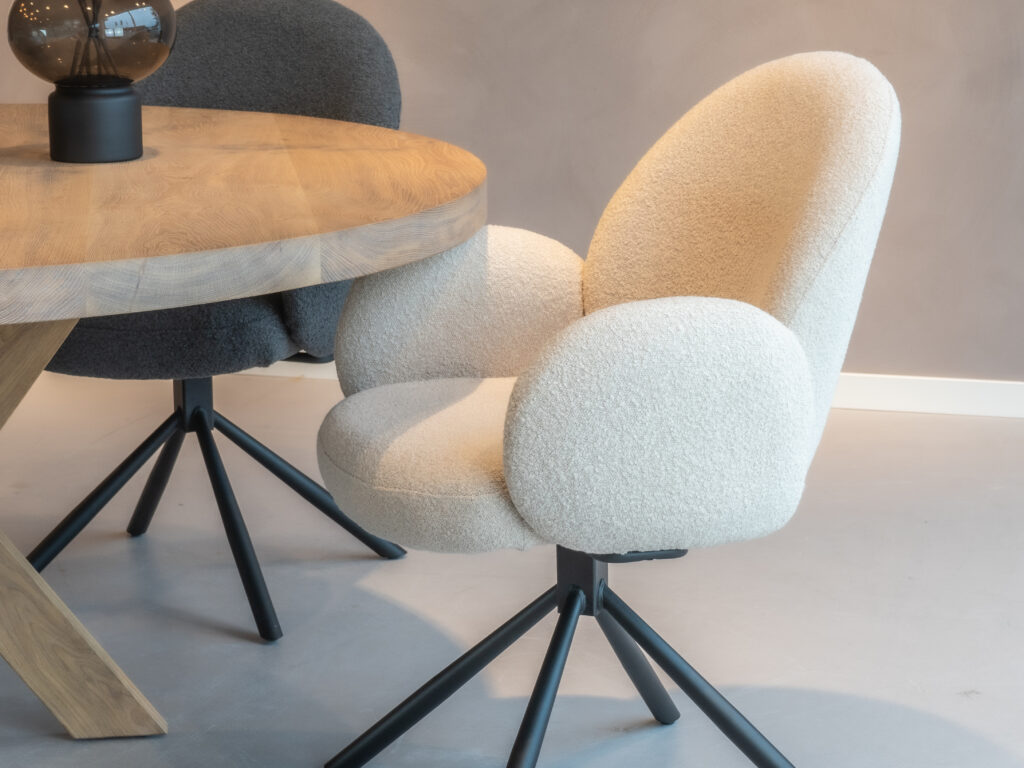 Beige eetkamerstoel met een modern ontwerp en zwarte poten.