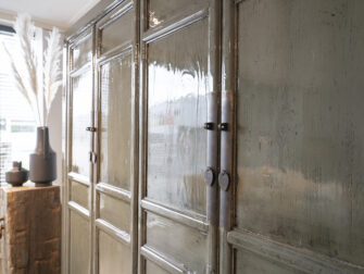 donkergroene opbergkast van oud hout met deuren