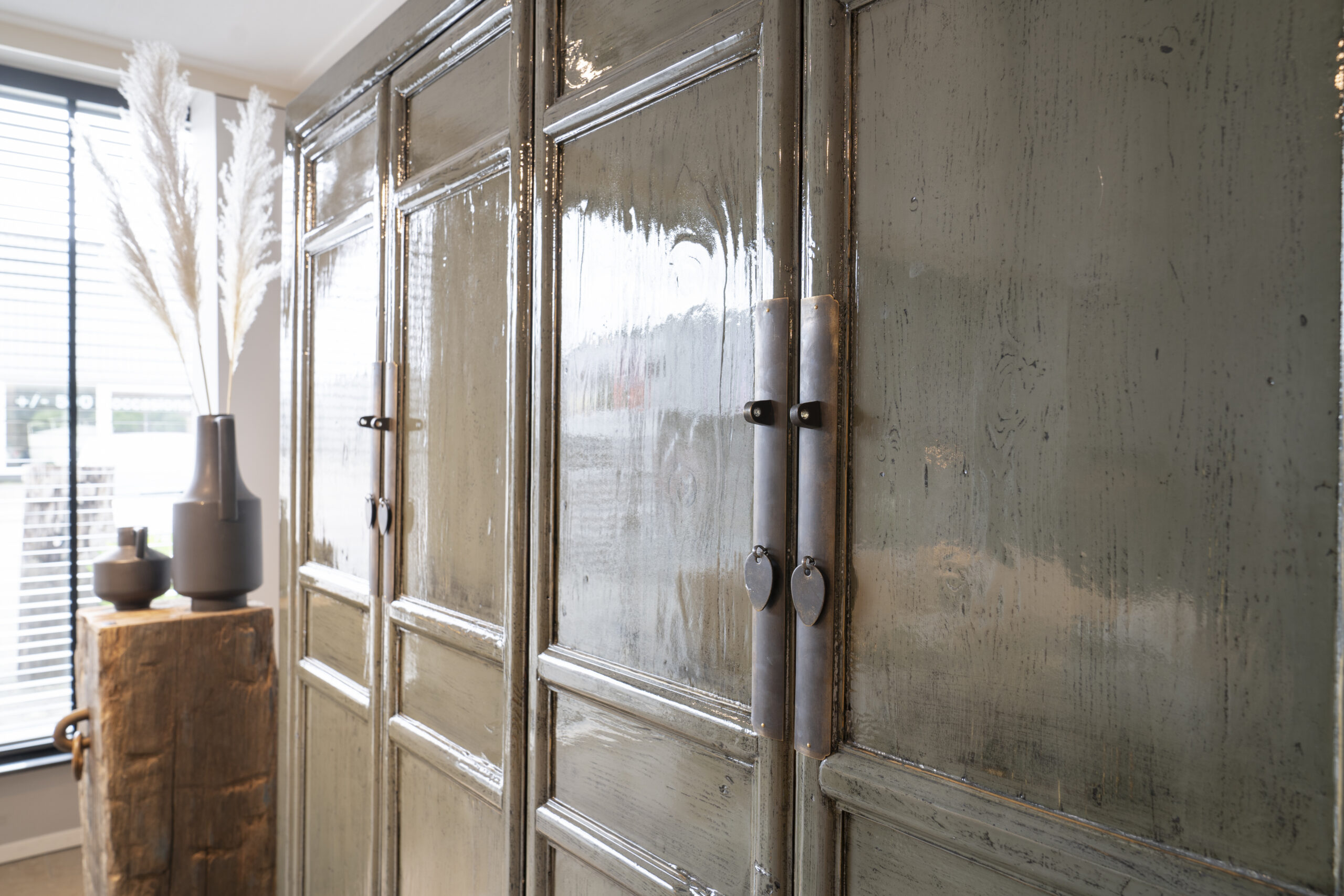 donkergroene opbergkast van oud hout met deuren