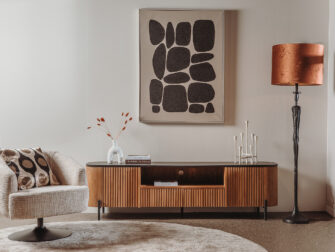 Modern design TV-meubel van gerecycled hout met elegante lattenfront en slanke zwarte pootjes