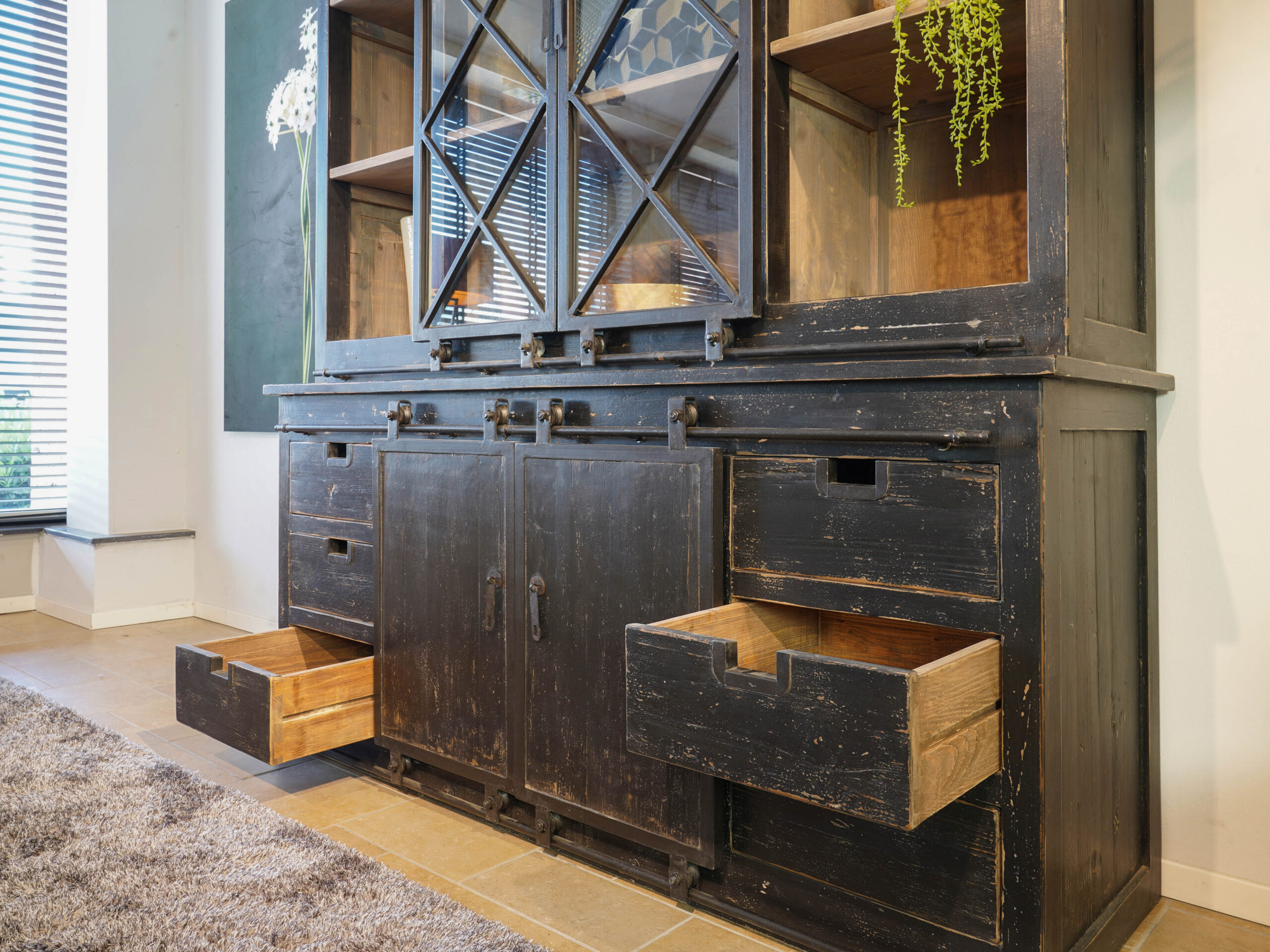 zwarte vitrinekast met glazen schuifdeuren